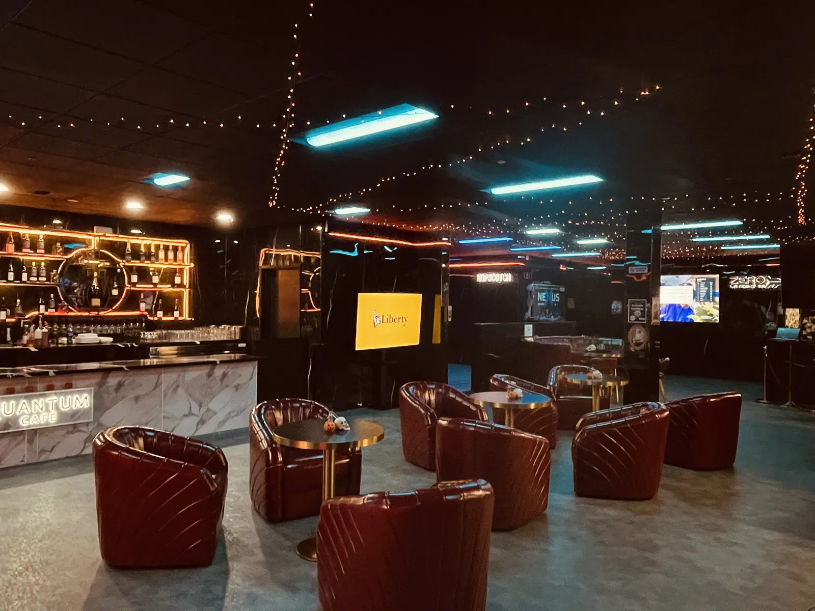 Red velvet lounge chairs and bar at Nexus Lounge in Halloween lighting